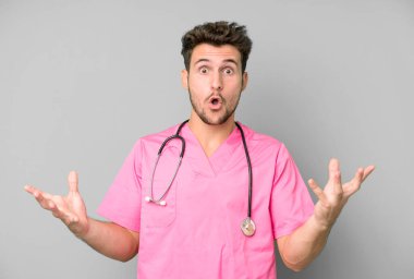 Yakışıklı genç, inanılmaz bir sürprizle şaşkına dönmüş ve hayrete düşmüştü. hemşire konsepti