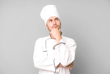 Yakışıklı genç düşünüyor, kuşkulu ve şaşkın hissediyor. Şef konsepti