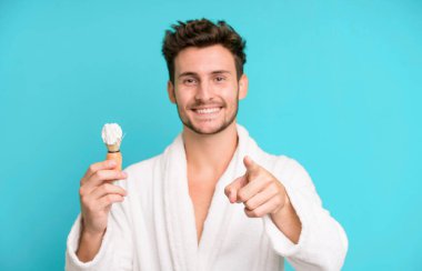 Yakışıklı genç kamerayı işaret ederek seni seçiyor bornoz giyiyor ve traş oluyor.