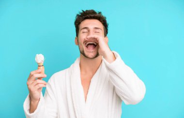 Yakışıklı genç kendini mutlu hissediyordu, elleri ağzının yanında, bornoz giymiş ve traş konseptiyle bağırıyordu.