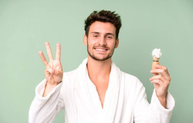 Yakışıklı genç gülümsüyor ve arkadaş canlısı görünüyor. Üçüncüyü bornoz giyip tıraş olurken gösteriyor.