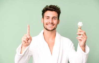 Yakışıklı genç gülümsüyor ve arkadaş canlısı görünüyor. Bir numara bornoz giyiyor ve tıraş oluyor.