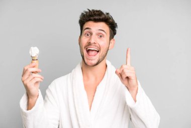 Güzel bir genç, bornoz giyip traş olma kavramını anladıktan sonra mutlu ve heyecanlı bir dahi gibi hissediyor.