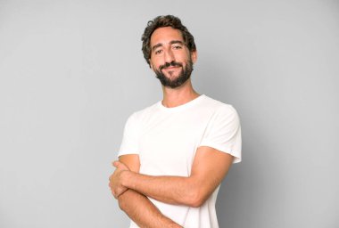 Genç çılgın adam utangaç ve neşeli bir şekilde gülüyor, arkadaş canlısı ve olumlu ama güvensiz bir tavırla.