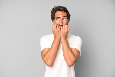 Genç çılgın adam endişeli, gergin, stresli ve korkmuş görünüyor, tırnaklarını yiyor ve yanal fotokopi alanı arıyor.