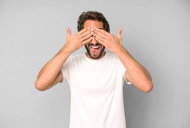 Genç çılgın adam gülümsüyor ve mutlu hissediyor, iki eliyle gözlerini kapatıyor ve inanılmaz bir sürpriz bekliyor.