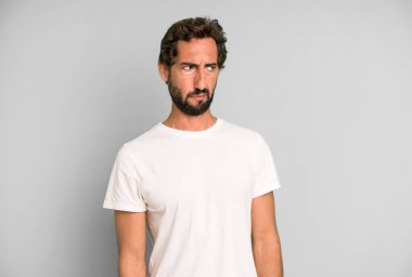 Genç çılgın adam üzgün, üzgün ya da kızgın ve olumsuz bir tavır takınıyor, anlaşmazlık içinde kaşlarını çatıyor.