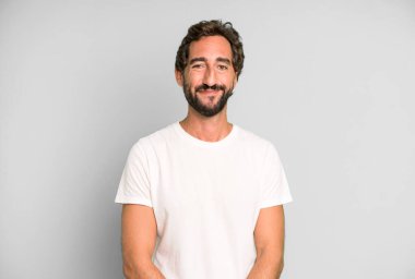 Genç çılgın adam pozitif ve kendinden emin gülümsüyor. Tatmin olmuş, arkadaş canlısı ve mutlu görünüyor.