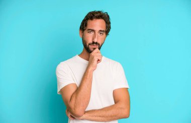 Genç çılgın adam ciddi görünüyor, kafası karışık, kararsız ve düşünceli, seçenekler ya da seçimler arasında şüpheci