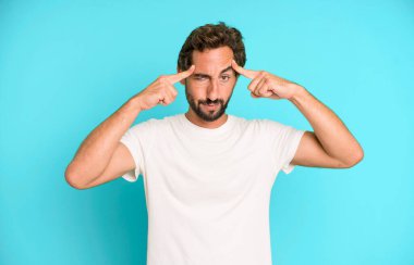 Ciddi ve konsantre görünümlü genç çılgın bir adam, beyin fırtınası yapıyor ve zorlu bir sorunu düşünüyor.