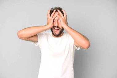 Genç çılgın adam ellerini kaldırıyor, ağzı açık, son derece şanslı, şaşırmış, heyecanlı ve mutlu hissediyor.