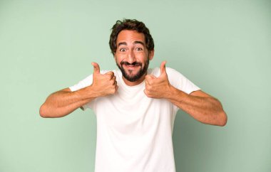 Genç çılgın adam gülümsüyor. Mutlu, pozitif, kendinden emin ve başarılı görünüyor.