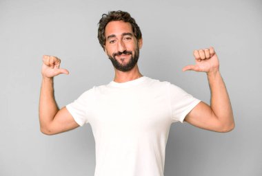 Genç çılgın adam gururlu, kibirli ve kendinden emin, tatmin olmuş ve başarılı görünüyor, kendini işaret ediyor.