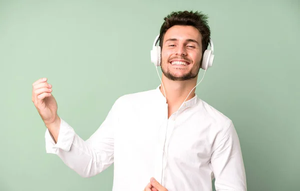 Junger Gutaussehender Mann Isoliert Musik Hörend Und Mit Kopfhörern Tanzend — Stockfoto