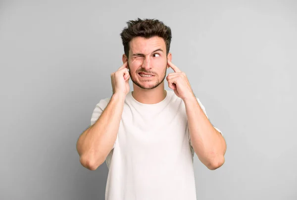 Joven Hombre Guapo Mirando Enojado Estresado Molesto Cubriendo Ambos Oídos —  Fotos de Stock