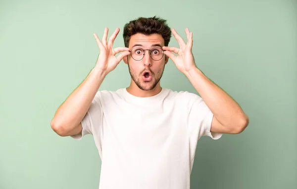 Ung Stilig Man Känner Chockad Förvånad Och Överraskad Hålla Glasögon — Stockfoto
