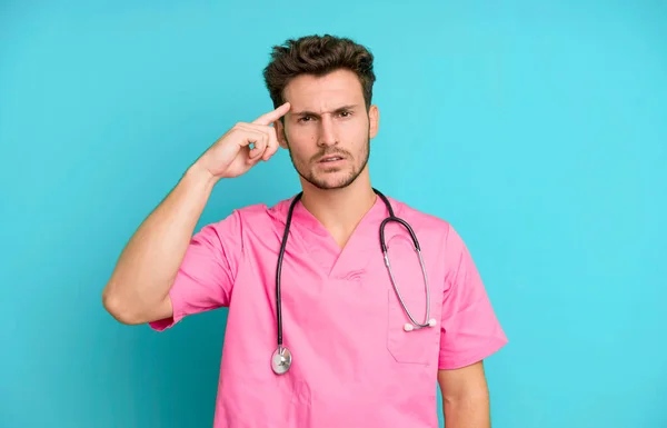 Handsome Teenager Feeling Confused Puzzled Showing You Insane Nurse Concept — Stock Photo, Image