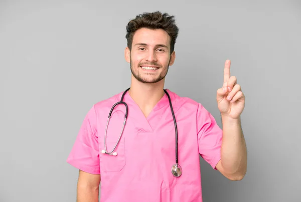 Guapo Adolescente Sonriendo Buscando Amigable Mostrando Número Uno Concepto Enfermera —  Fotos de Stock