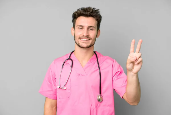 Guapo Adolescente Sonriendo Buscando Amigable Mostrando Número Dos Concepto Enfermera —  Fotos de Stock