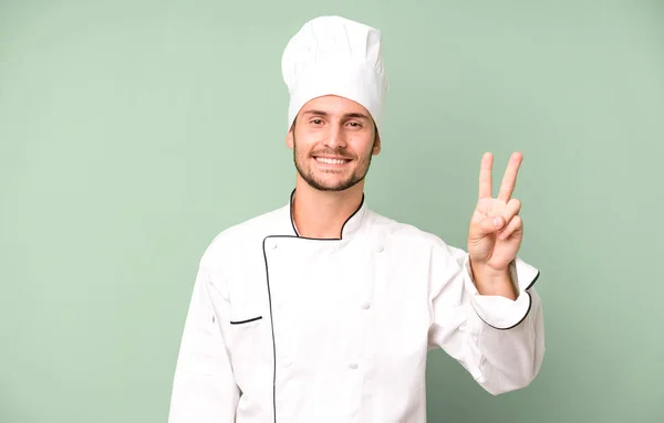 Guapo Adolescente Sonriendo Buscando Amigable Mostrando Número Dos Concepto Chef — Foto de Stock
