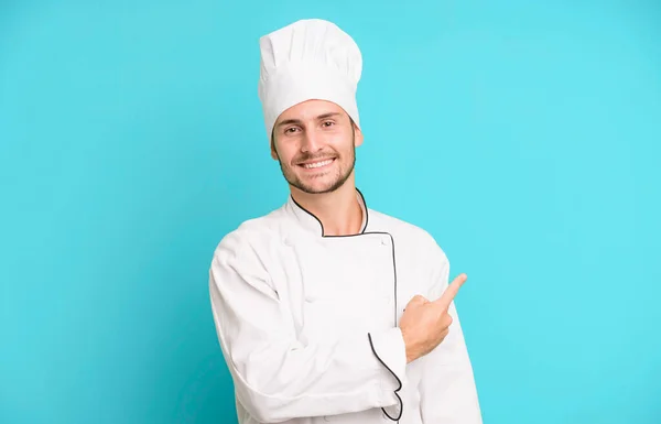 英俊的少年兴高采烈地笑着 感到快乐 指着旁边 厨师概念 — 图库照片