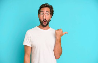 Genç, çılgın, sakallı ve etkileyici bir adam. Yanında fotokopi odası var.