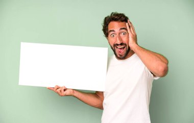 Genç, çılgın, sakallı ve etkileyici bir adam. Yanında fotokopi odası var.