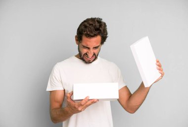 Genç, çılgın, sakallı ve anlamlı bir adam elinde boş bir paket kutusu tutuyor.