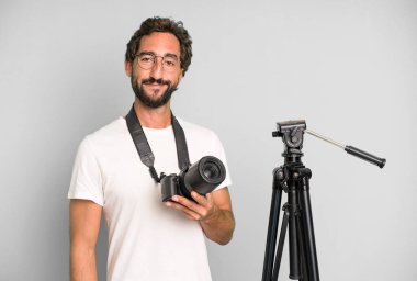 Genç, çılgın, sakallı ve fotoğraf makinesi olan etkileyici bir adam. fotoğrafçı konsepti