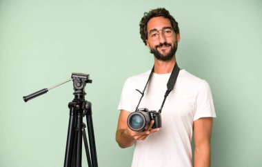 Genç, çılgın, sakallı ve fotoğraf makinesi olan etkileyici bir adam. fotoğrafçı konsepti