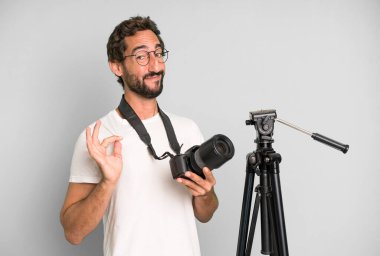 Genç, çılgın, sakallı ve fotoğraf makinesi olan etkileyici bir adam. fotoğrafçı konsepti