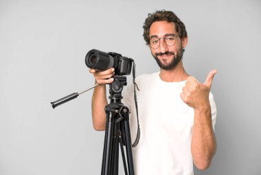 Genç, çılgın, sakallı ve fotoğraf makinesi olan etkileyici bir adam. fotoğrafçı konsepti