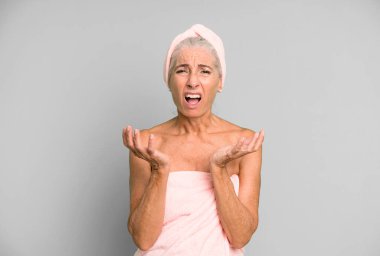 Gri saçlı güzel kadın umutsuz, hayal kırıklığına uğramış ve stresli görünüyor. Bornoz ve havlu giyiyor. güzellik konsepti