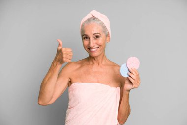 Gri saçlı, son sınıf güzeli, bornoz giyip makyaj yapan güzel bir kadın..