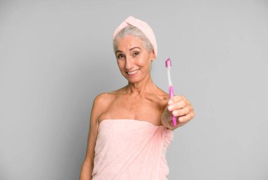 Gri saçlı, son sınıf güzeli, bornoz giyip makyaj yapan güzel bir kadın..