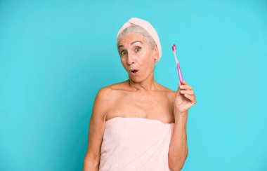 Gri saçlı, son sınıf güzeli, bornoz giyip makyaj yapan güzel bir kadın..