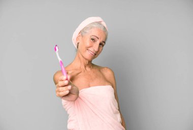 Gri saçlı, son sınıf güzeli, bornoz giyip makyaj yapan güzel bir kadın..