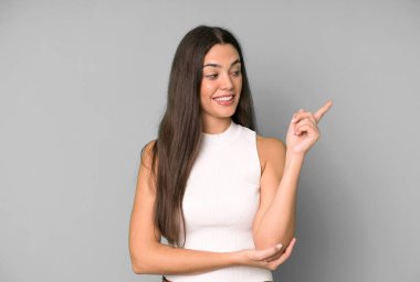 İspanyol güzel kadın mutlu bir şekilde gülümsüyor ve yan bakıyor, merak ediyor, düşünüyor ya da bir fikri var.