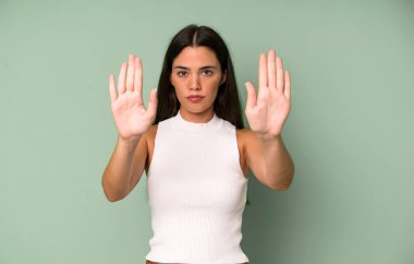 İspanyol güzel kadın ciddi, mutsuz, kızgın ve hoşnutsuz görünüyor. Girmeyi yasaklıyor ya da iki avucunun içinde de dur diyor.