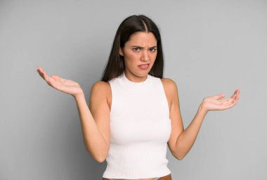 İspanyol güzel kadın şaşkın, şaşkın ve stresli görünüyor, farklı seçenekler arasında merak ediyor, kararsız hissediyor