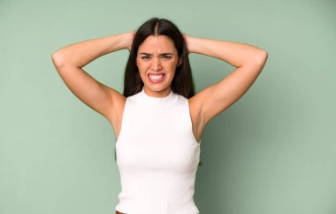 İspanyol güzel kadın kendini stresli, endişeli, endişeli ya da korkmuş hissediyor. Elleri başının üstünde, hatayla panikliyor.