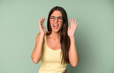 İspanyol asıllı güzel bir kadın panik ya da öfke içinde bağırıyor, şok olmuş, korkmuş ya da öfkeli, elleri başının yanında.