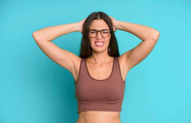 İspanyol güzel kadın kendini stresli, endişeli, endişeli ya da korkmuş hissediyor. Elleri başının üstünde, hatayla panikliyor.