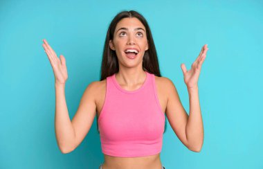 İspanyol güzel kadın kendini mutlu, şaşkın, şanslı ve şaşırmış hissediyor. Zaferi kutlarken iki elini havaya kaldırıyor.