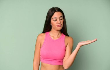 İspanyol güzel kadın mutlu ve güler yüzlü, elinde tuttuğu bir nesneye ya da konsepte bakıyor.