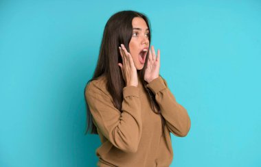 İspanyol güzel kadın mutlu, heyecanlı ve şaşırmış hissediyor, iki eli yüzü yana bakıyor