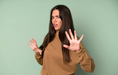 İspanyol güzel kadın korkmuş hissediyor, geri çekiliyor ve korku ve panik içinde bağırıyor, kabusa tepki veriyor.