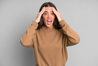 İspanyol güzel kadın dehşete kapılmış ve şok olmuş hissediyor, ellerini havaya kaldırıyor ve bir hata yüzünden panikliyor.