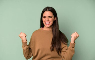 İspanyol güzel kadın mutlu, pozitif ve başarılı hissediyor, zaferi, başarıları veya iyi şansı kutluyor.