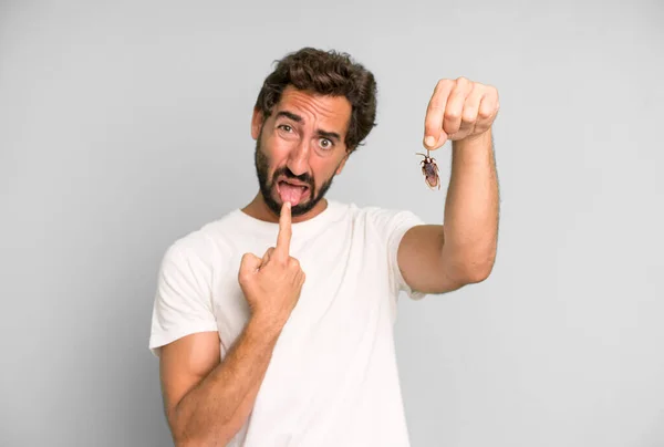 指で虫を持つ若い狂人髭と表情豊かな男 — ストック写真